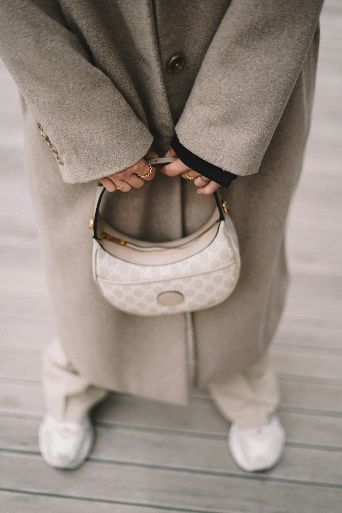 Cream curved mini bag styled with a stone coat